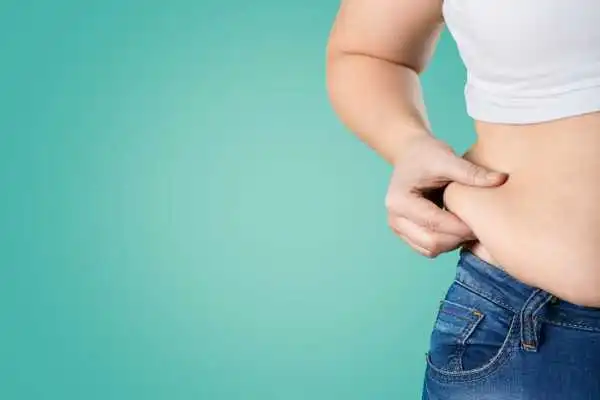 Image of woman pinching her love handles to show weight gain Doncaster